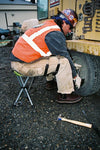 Man sitting on Travel Chair Slacker Camping Stool while changing tire on tractor.